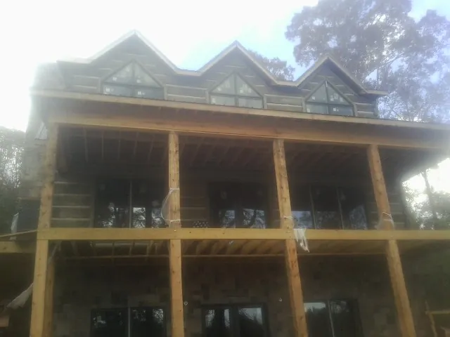 Dormers and porch framing on a large log home under construction — Roof Coating work by our crew in Readsboro