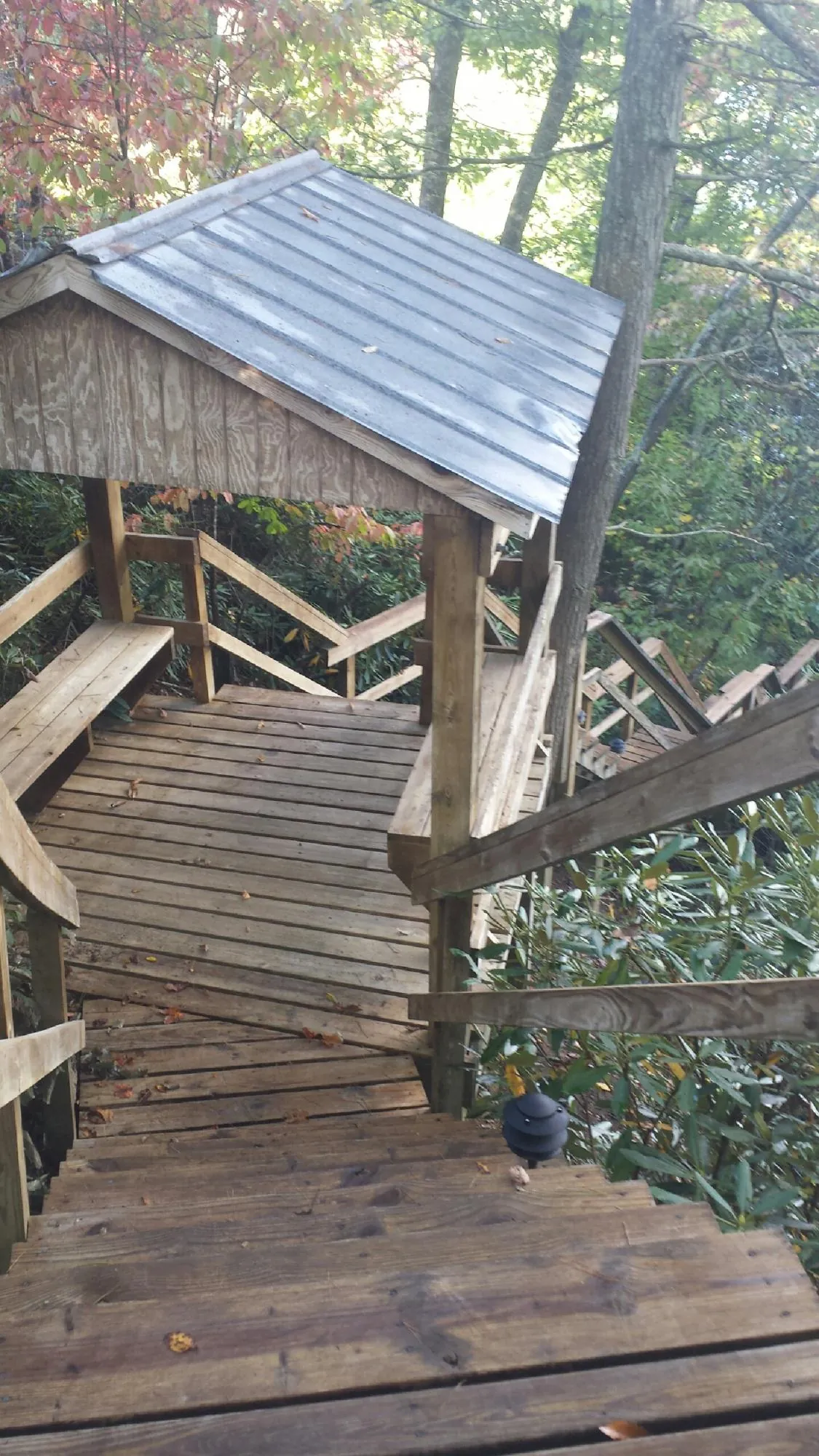 Metal roofed shelter over wooden steps on a wooded walkway — Skylight Repair & Installation work by our crew in Readsboro