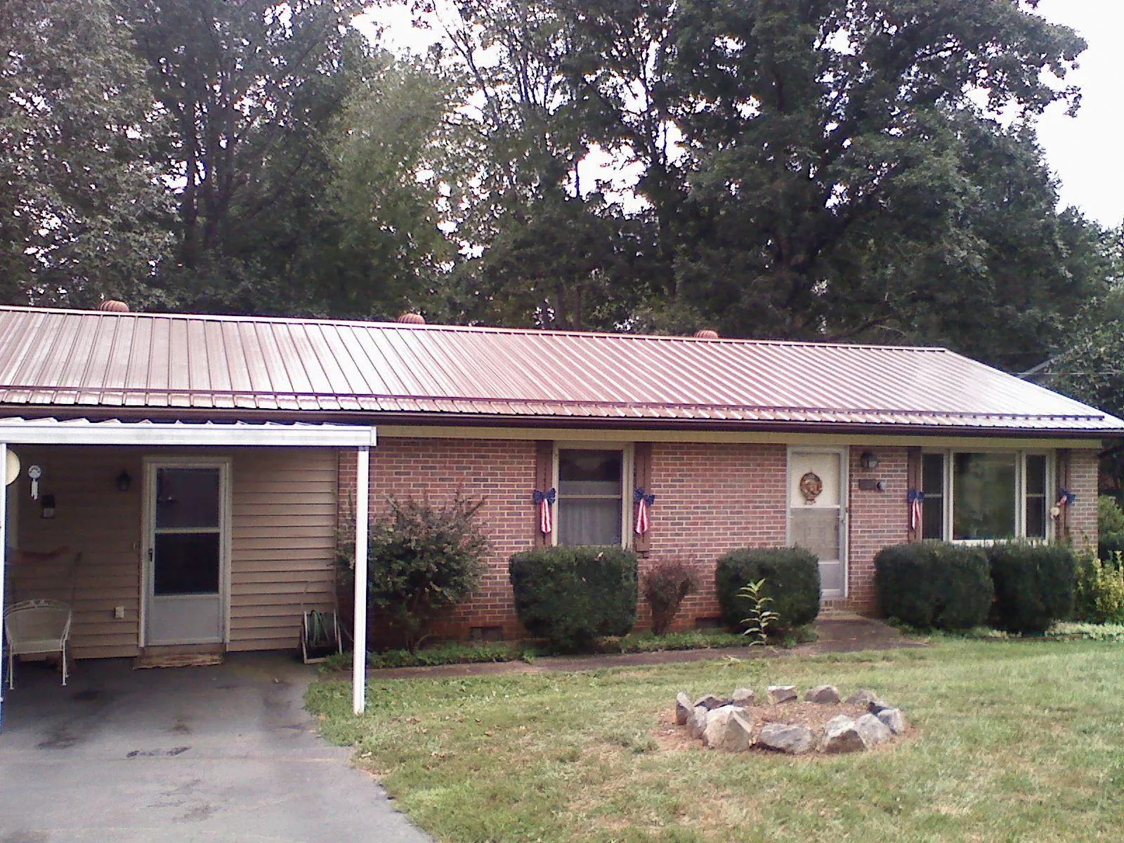 Bronze metal roof and carport on a brick ranch home — Roof Repair work by our crew in Readsboro